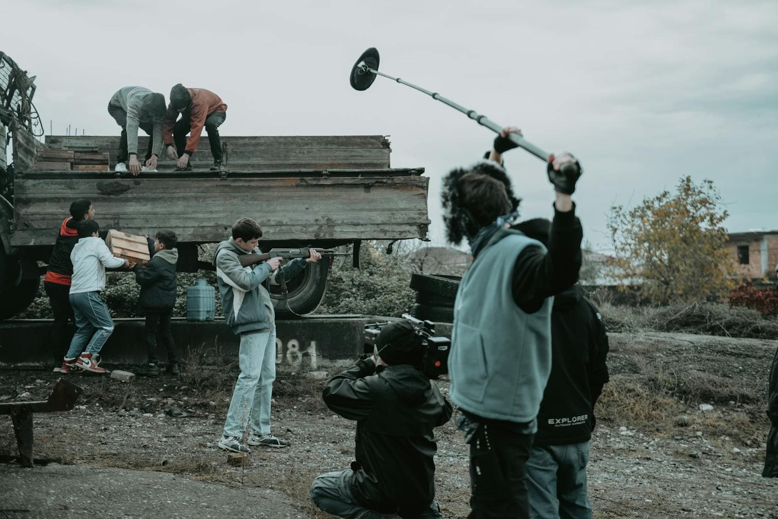 A film crew shooting a scene on location, with a camera operator and a boom operator capturing the action